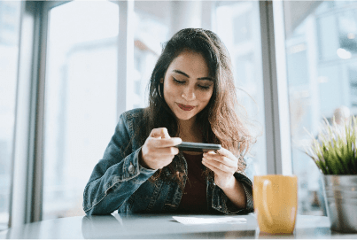 Young, brunette woman making a mobile check deposit with her phone