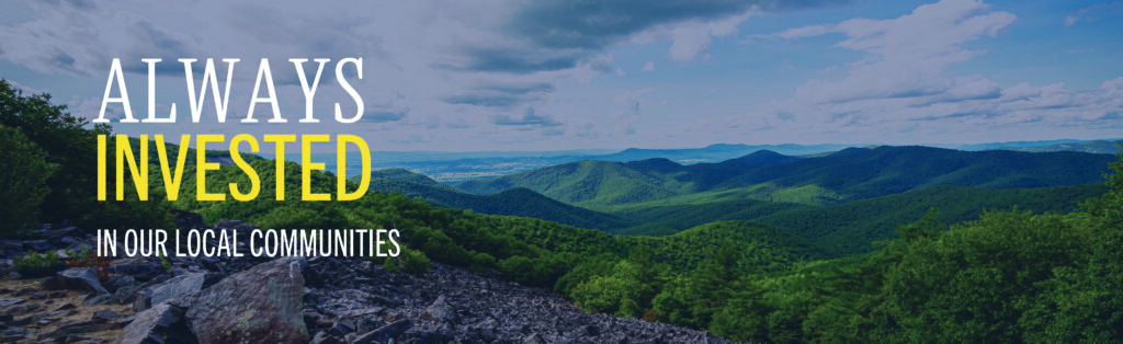An the picturesque Blue Ridge Mountains with words "Always Invested in our local communities" on top of the picture.